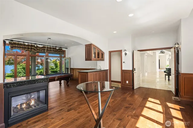 a living room with furniture a large window and wooden floor