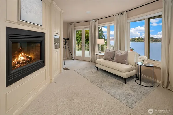 a living room with furniture a floor to ceiling window and a fireplace