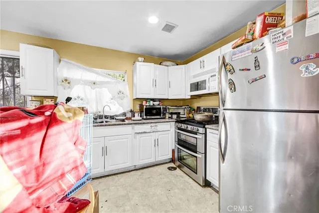 a kitchen with stainless steel appliances granite countertop a refrigerator a stove a sink and dishwasher