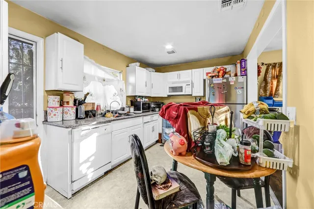 a kitchen with stainless steel appliances kitchen island granite countertop a table and chairs in it