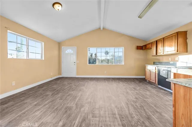 an empty room with windows & cabinet