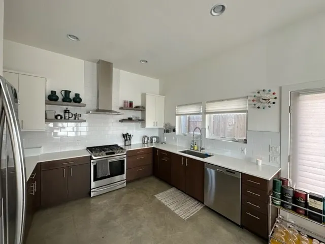 a kitchen with stainless steel appliances granite countertop a sink and a stove