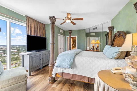 a bathroom with a granite countertop sink a mirror a glass door a shower and vanity