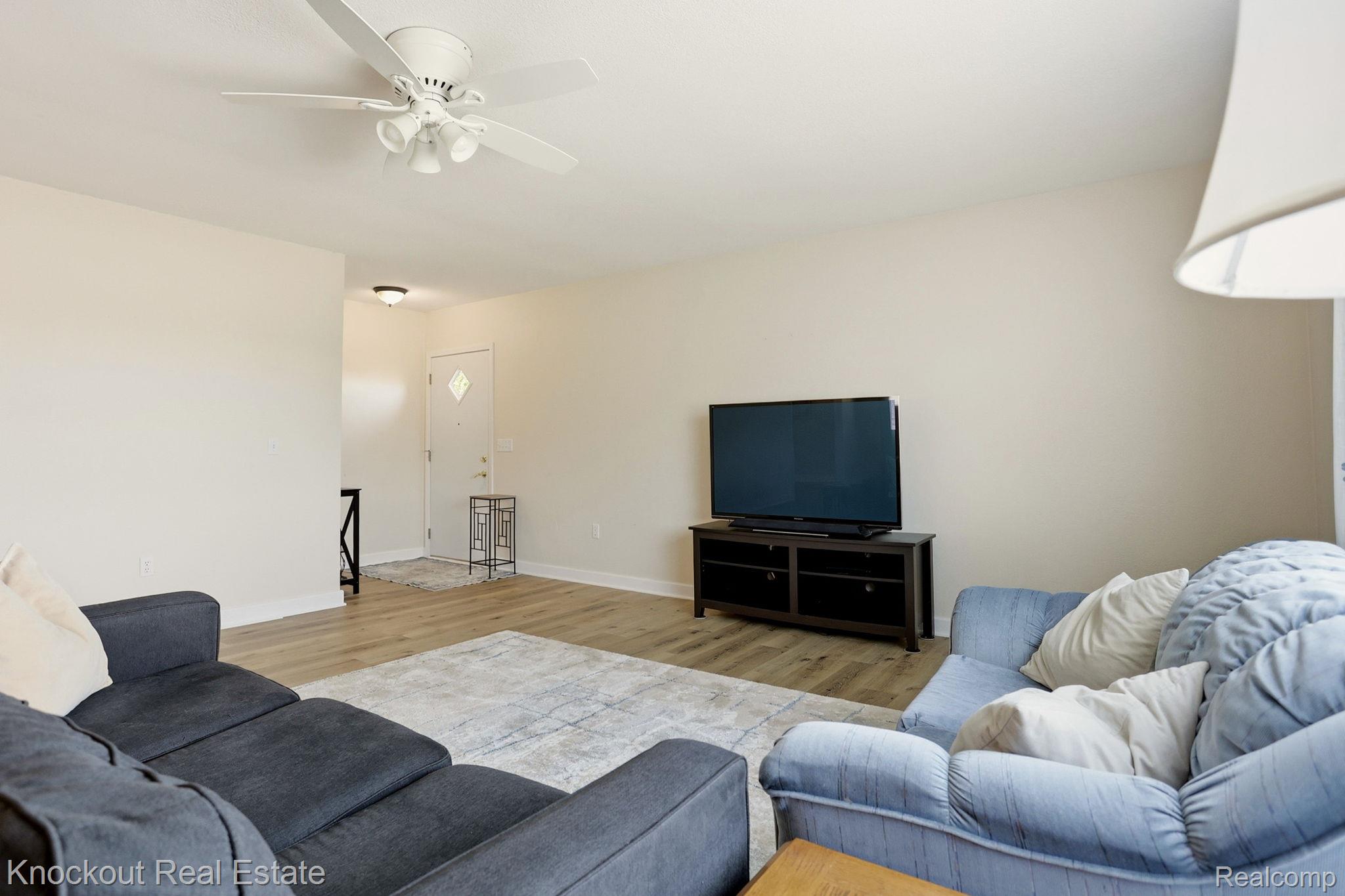 9941 Lange Road Birch Run, MI 48415 - Photo 7 of 42 Open-concept living area with wood-finish flooring, a contemporary ceiling fan with integrated lighting, and neutral wall tones