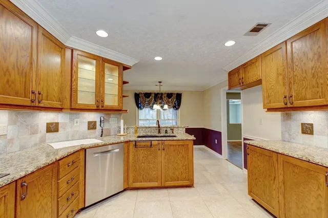 a kitchen with stainless steel appliances granite countertop wooden cabinets a sink and dishwasher