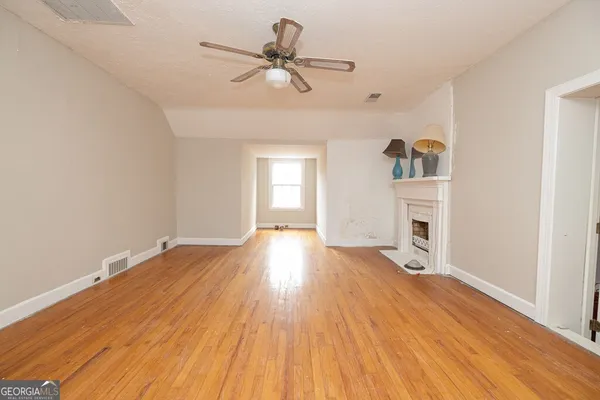 a view of a livingroom with wooden floor and a ceiling fan