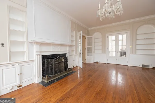 wooden floor fireplace and windows in an empty room