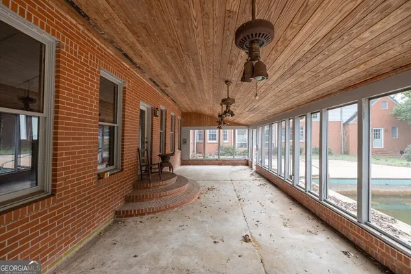 a view of a porch with furniture and floor to ceiling window
