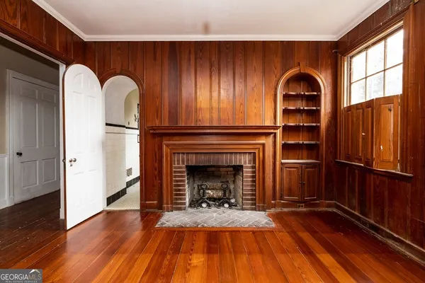 a view of an empty room with exposed radiator and fireplace