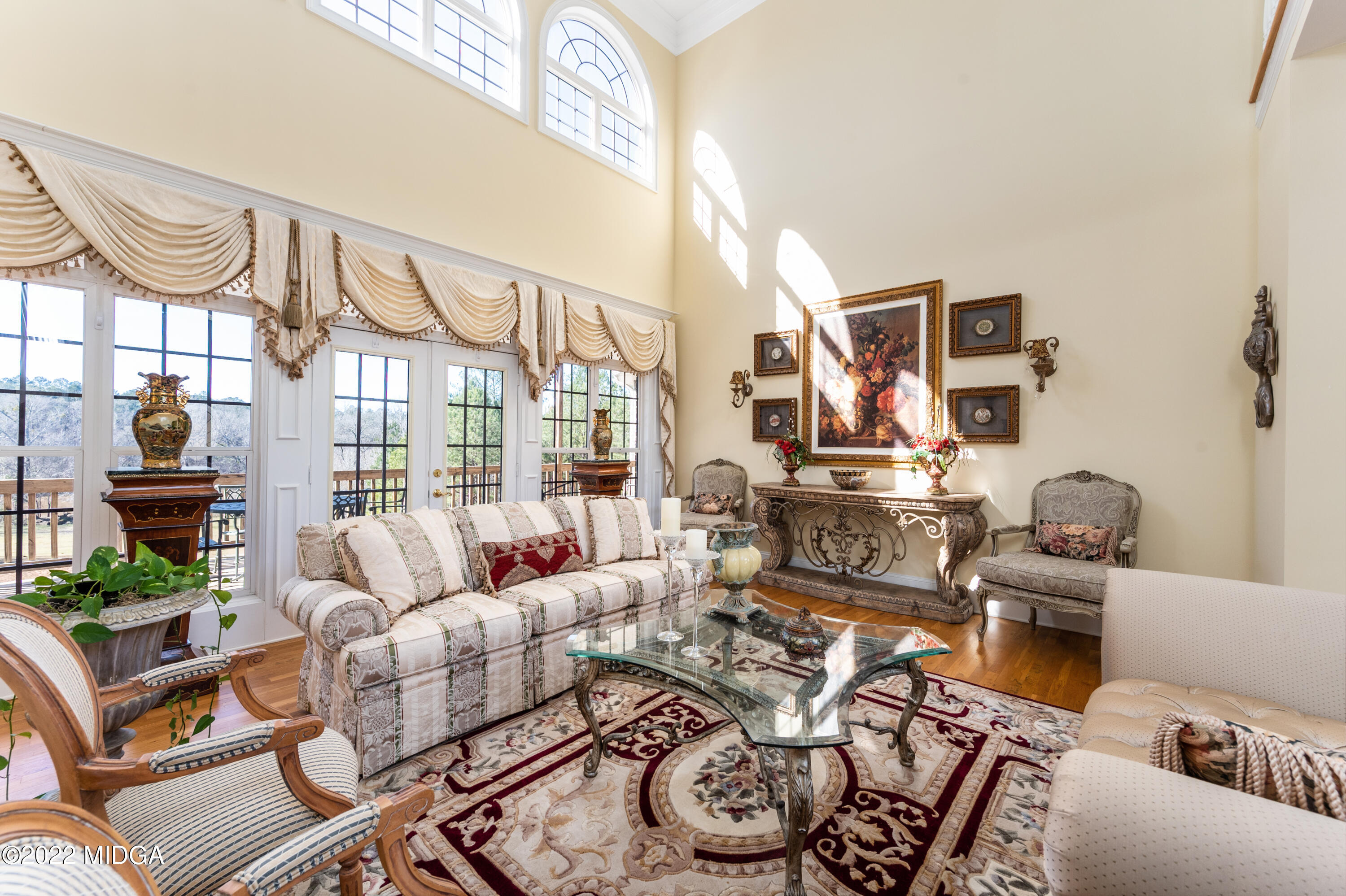 176 Tumbling Shoals Drive Gray, GA 31032 - Photo 23 of 51 a living room with furniture a rug and a floor to ceiling window