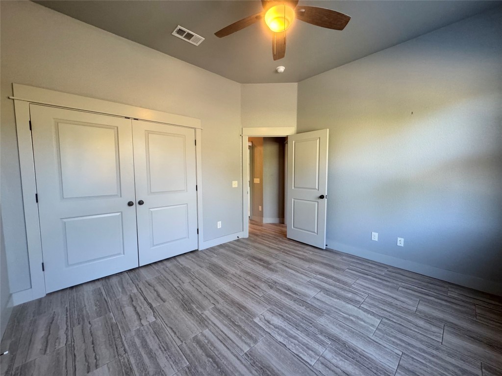 290 Hugo Road, Unit A San Marcos, TX 78666 - Photo 14 of 25 an empty room with wooden floor and a ceiling fan