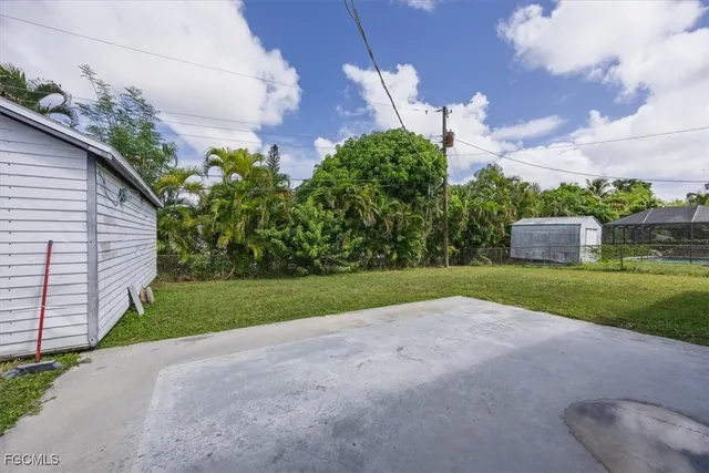 a view of a house with a yard and large tree