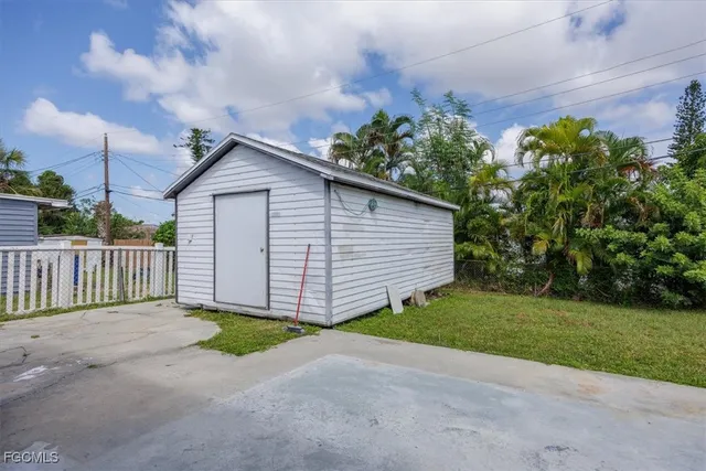 a view of a small house with wooden fence