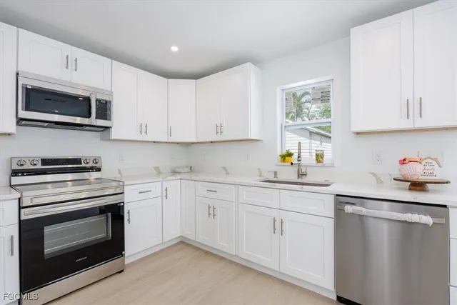 a kitchen with cabinets stainless steel appliances and sink