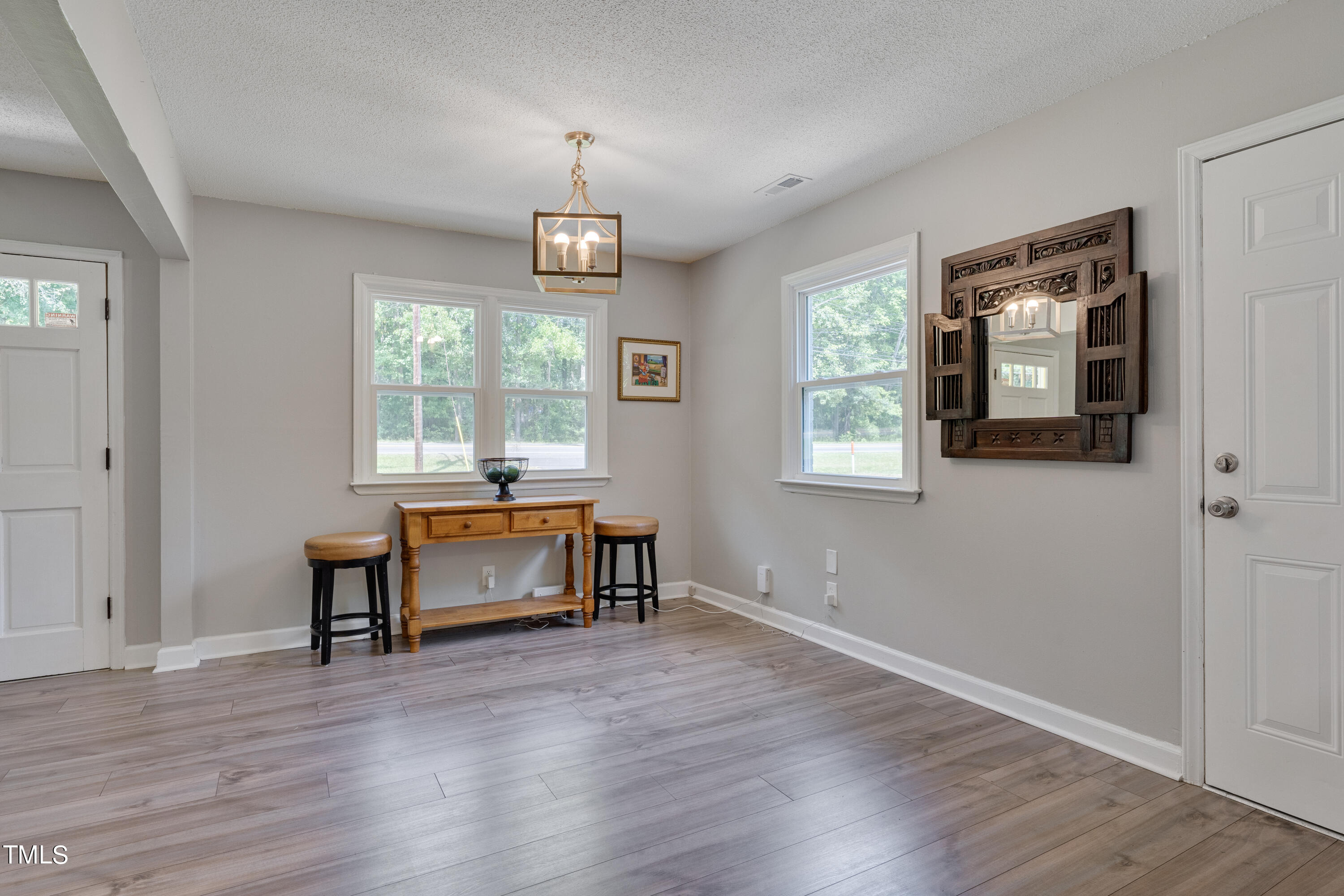 1620 Riddle Road Durham, NC 27713 - Photo 5 of 18 an empty room with wooden floor cabinet and windows