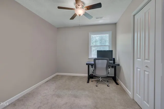 a view of a workspace with furniture and a window