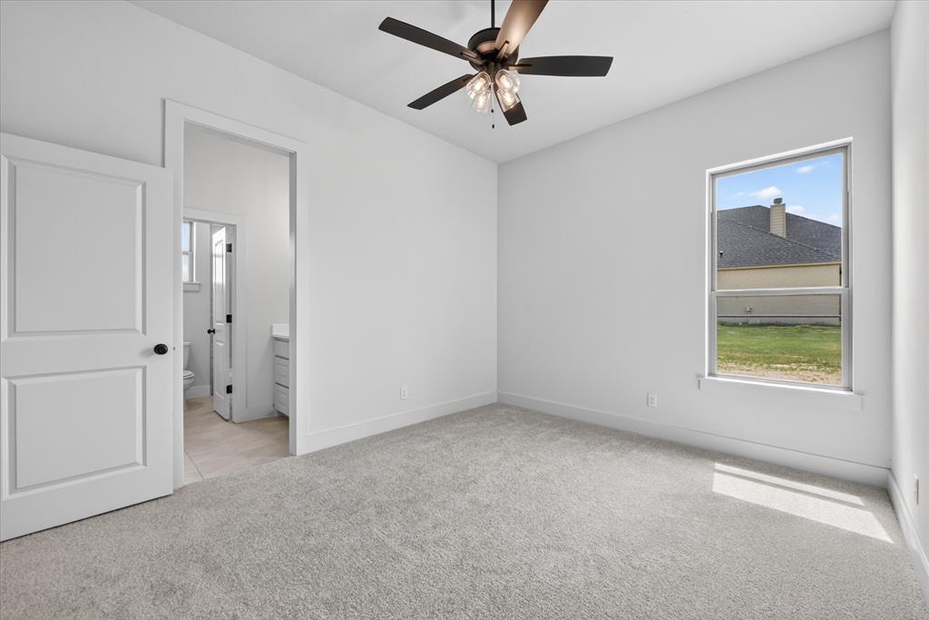 517 Longhorn Lane Springtown, TX 76082 - Photo 26 of 39 Unfurnished bedroom featuring light colored carpet, ceiling fan, and ensuite bath