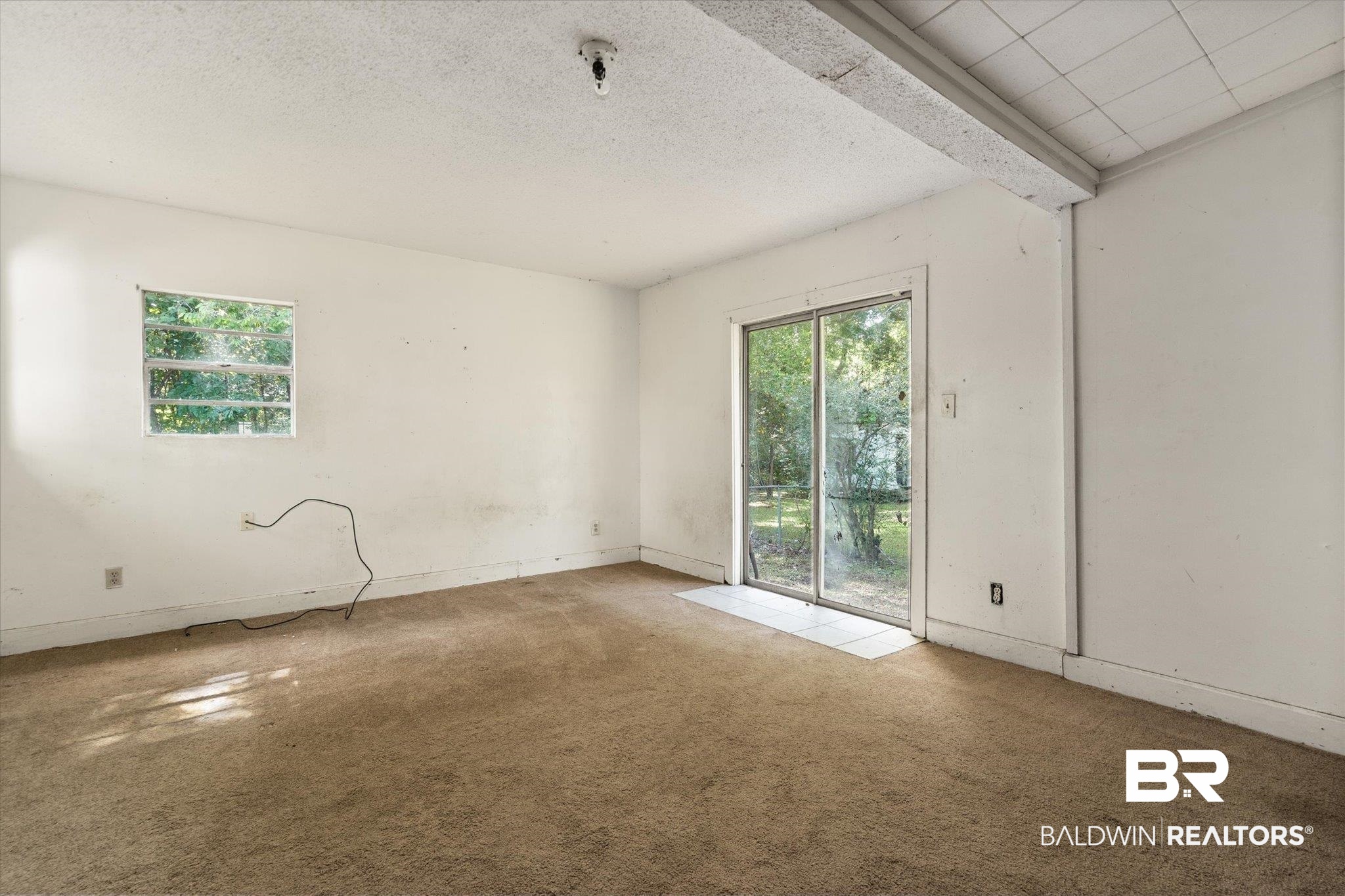 672 Burden Street Mobile, AL 36607 - Photo 8 of 20 Spare room with carpet floors, baseboards, and a textured ceiling