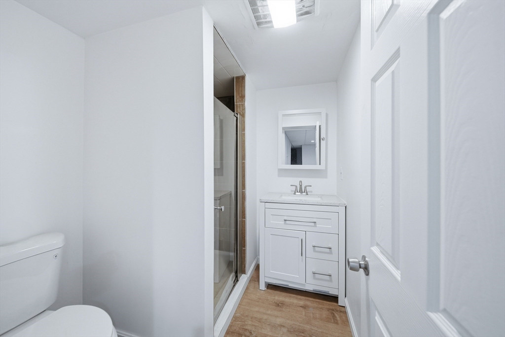 39 Hawthorne Street, Unit 39 Boston, MA 02119 - Photo 27 of 33 a bathroom with a toilet sink and mirror