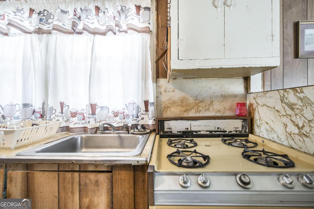 205 Georgia Avenue Fort Valley, GA 31030 - Photo 13 of 23 a kitchen with a stove and a sink