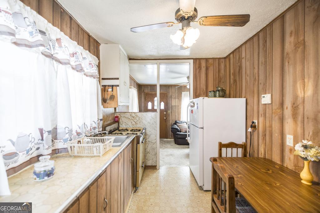 205 Georgia Avenue Fort Valley, GA 31030 - Photo 14 of 23 a kitchen with sink a refrigerator and chairs