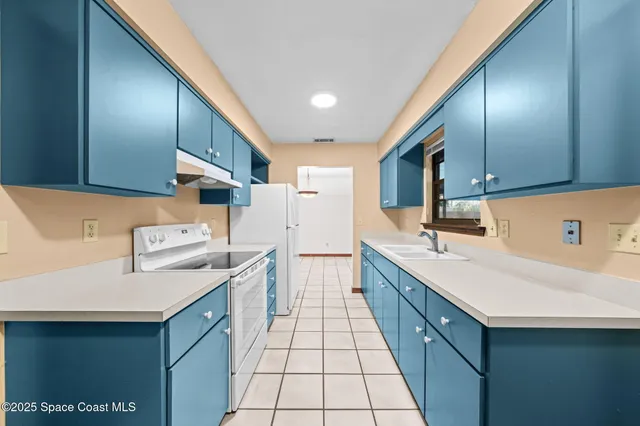 a kitchen with stainless steel appliances granite countertop a sink a stove and a refrigerator