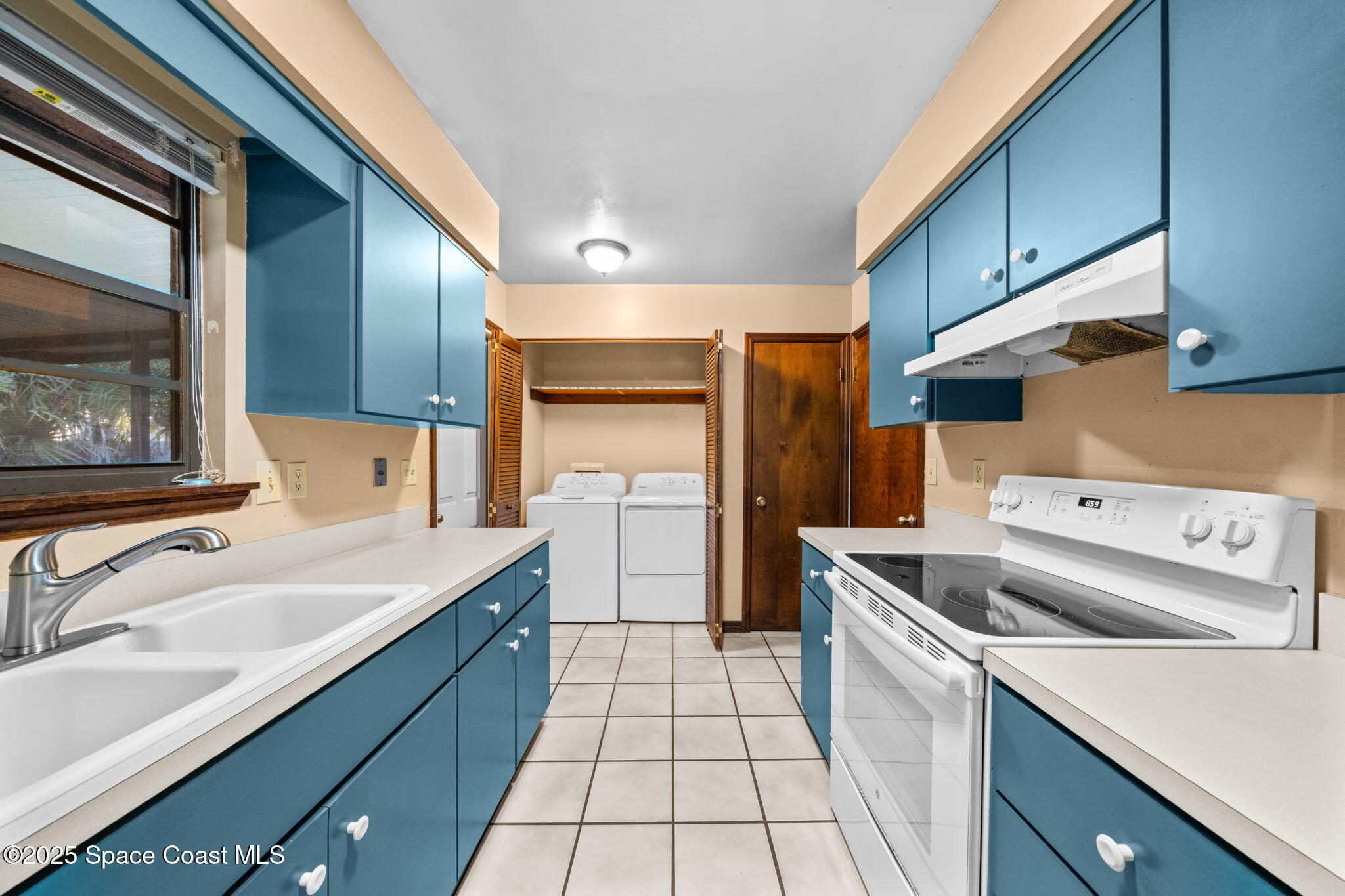410 Albenga Road Northwest Palm Bay, FL 32907 - Photo 12 of 23 a kitchen with a sink cabinets and stainless steel appliances