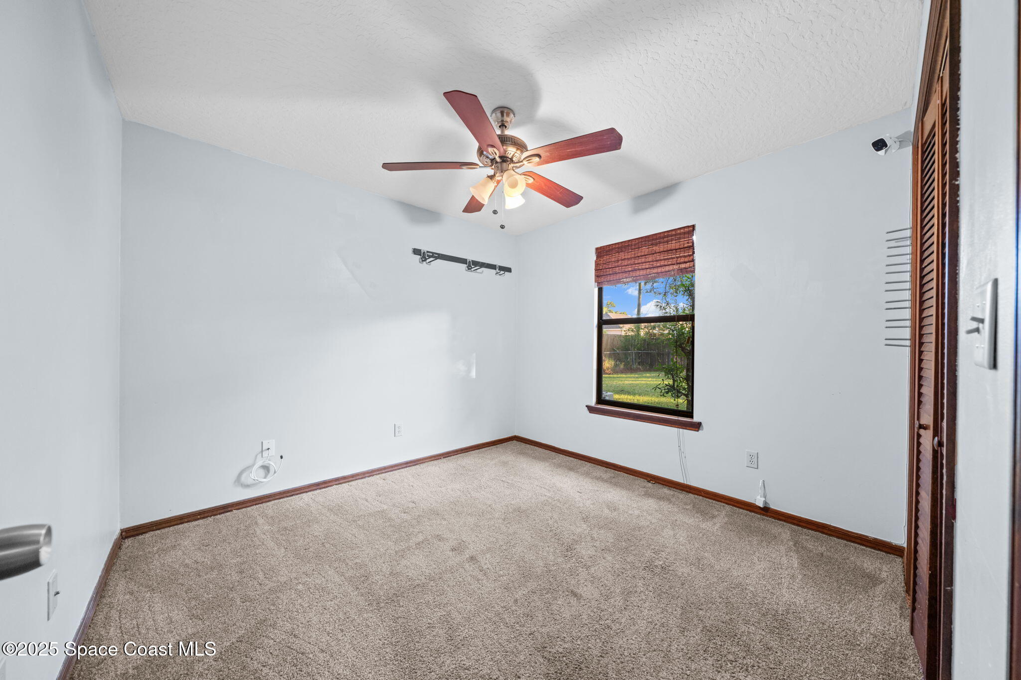410 Albenga Road Northwest Palm Bay, FL 32907 - Photo 14 of 23 an empty room with windows and fan