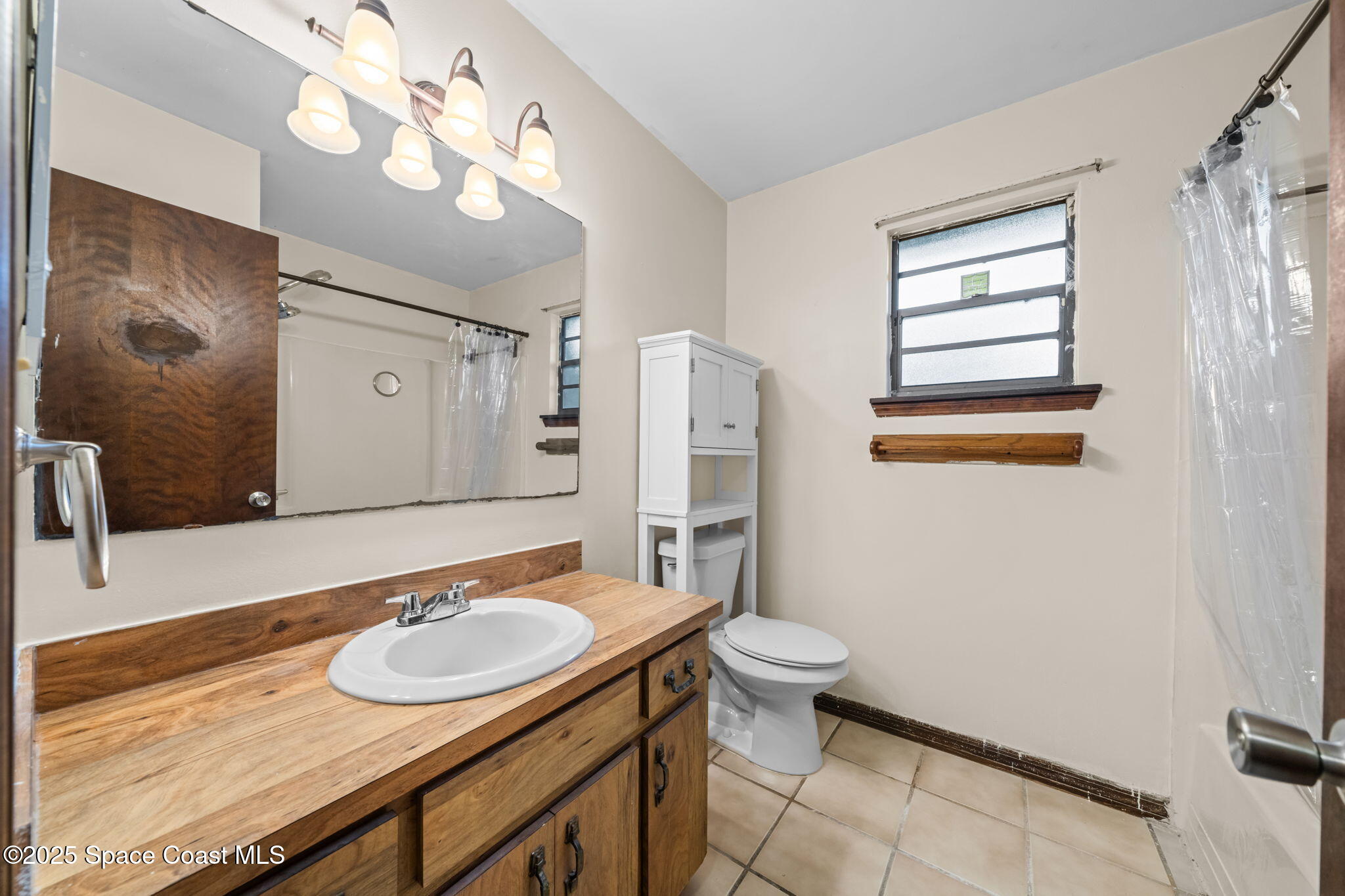 410 Albenga Road Northwest Palm Bay, FL 32907 - Photo 15 of 23 a bathroom with a sink a toilet and a mirror