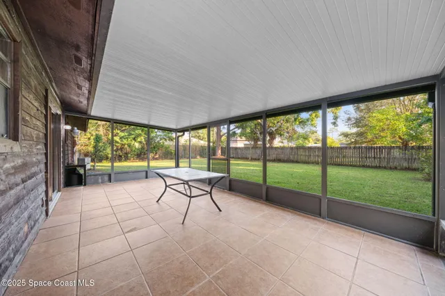 a view of a porch with chairs and backyard