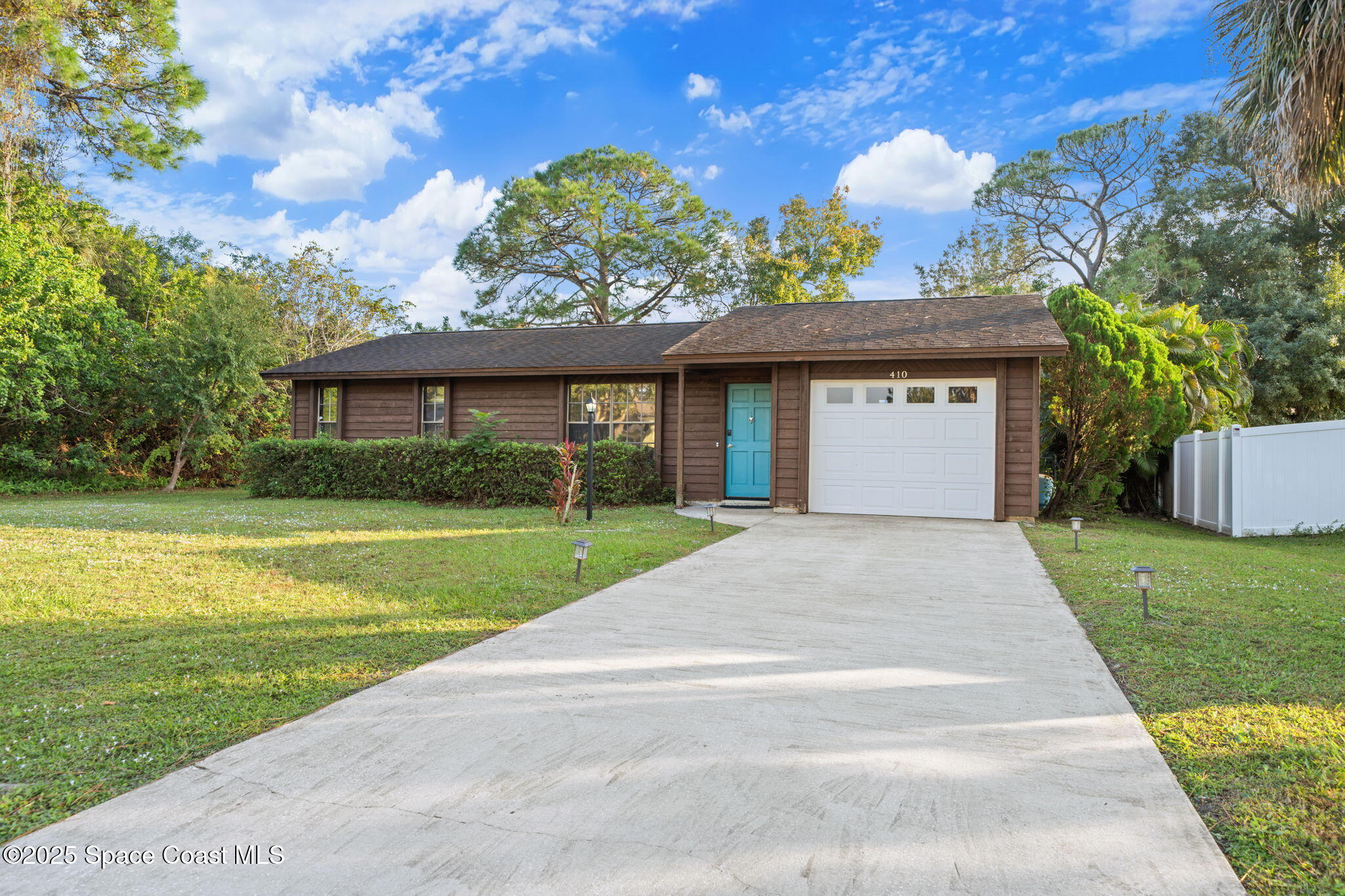 410 Albenga Road Northwest Palm Bay, FL 32907 - Photo 2 of 23 a front view of a house with garden