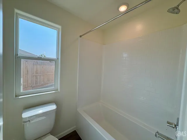 a white bath tub sitting next to a toilet