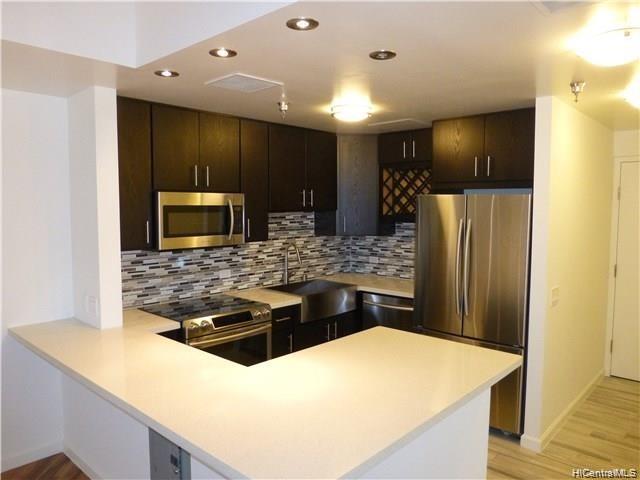 a kitchen with stainless steel appliances kitchen island granite countertop a stove refrigerator and microwave