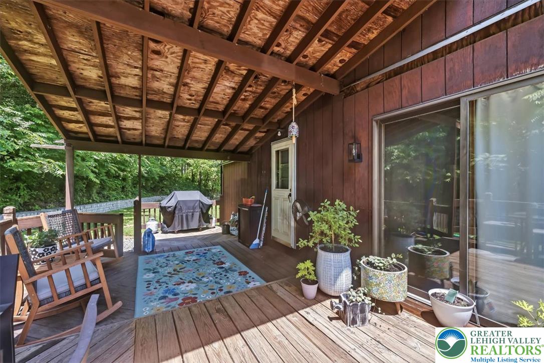 5340 2nd Street Whitehall, PA 18052 - Photo 6 of 30 A spacious wood deck, partially covered, extends living outdoors amidst mature greenery.