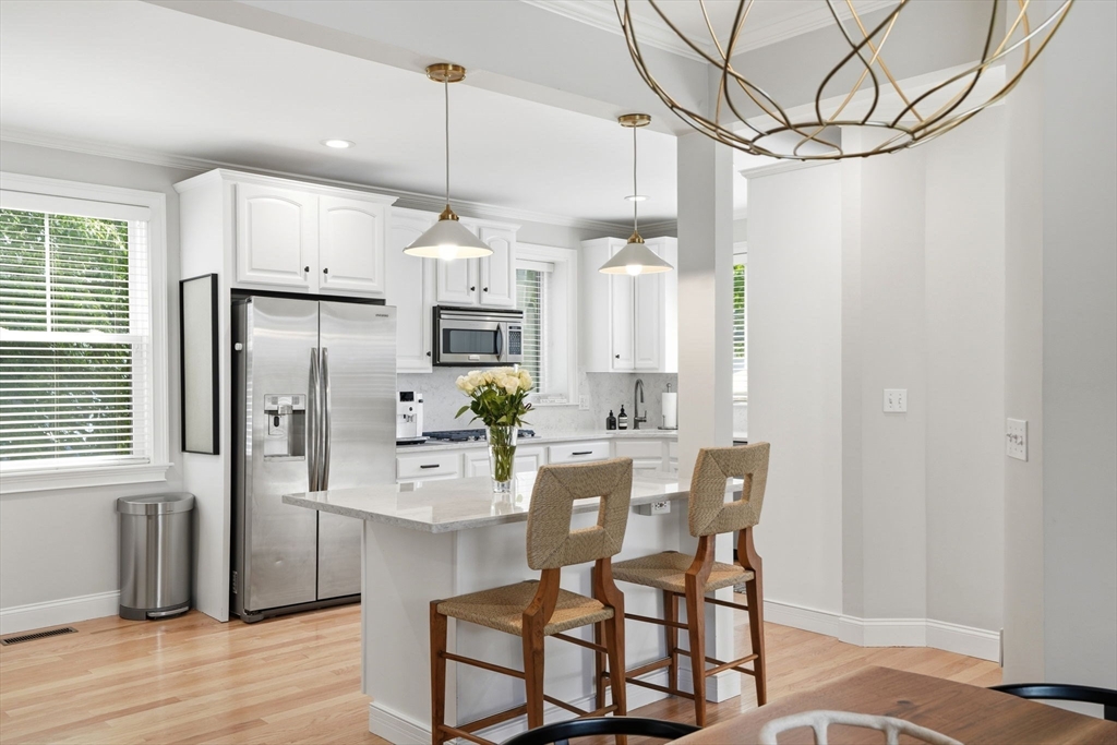 59 Elm Street Hingham, MA 02043 - Photo 11 of 33 a kitchen with stainless steel appliances a dining table chairs and wooden floor