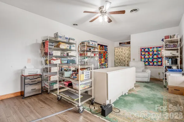 a living room with furniture and a baby crib