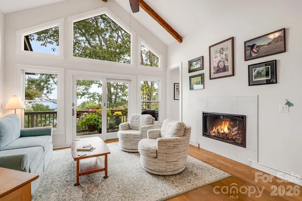 a living room with furniture a fireplace and a large window