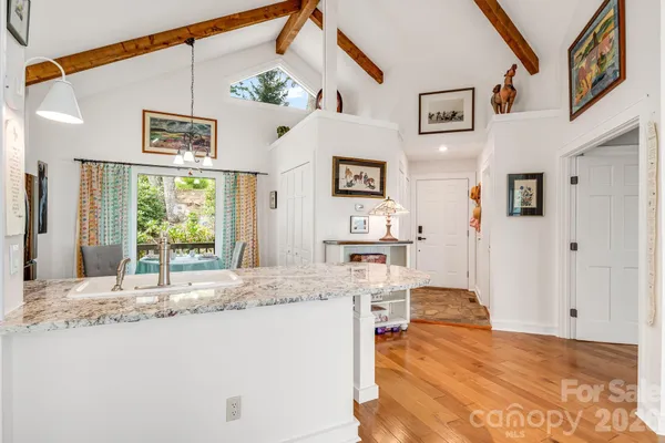 a living room with kitchen island granite countertop furniture and a large window