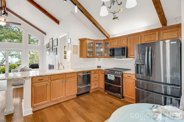 a kitchen with stainless steel appliances granite countertop a sink stove and refrigerator