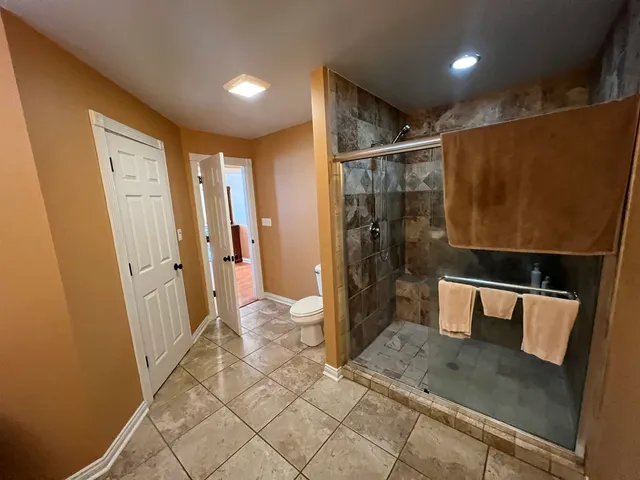 a bedroom with a bed dresser and a flat tv screen