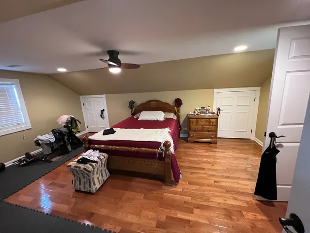 a dining room with wooden floor a chandelier a wooden table and chairs
