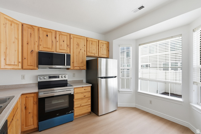 793 North 150 E Street Springville, UT 84663 - Photo 8 of 26 Kitchen featuring natural wood cabinetry, light-toned countertops, and stainless steel appliances including a refrigerator, range, and microwave