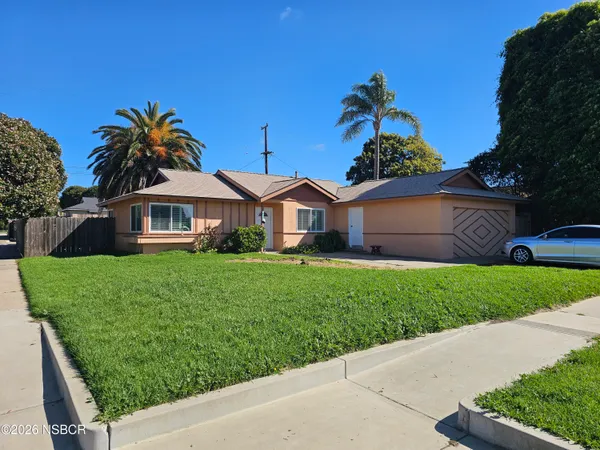 a front view of a house with a garden and plants
