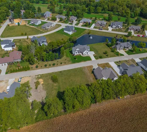 a view of a city street with a yard and large trees