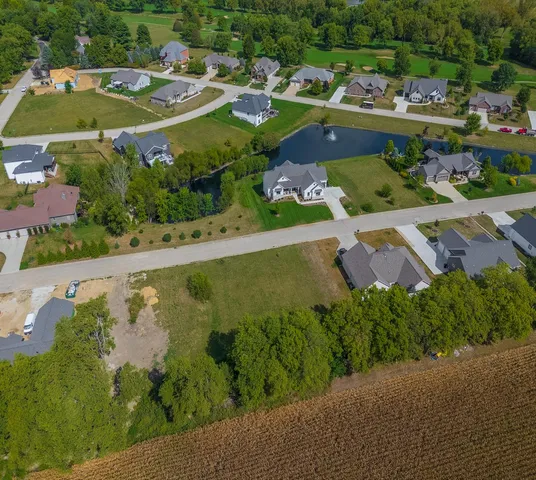a view of a city street with a yard and large trees