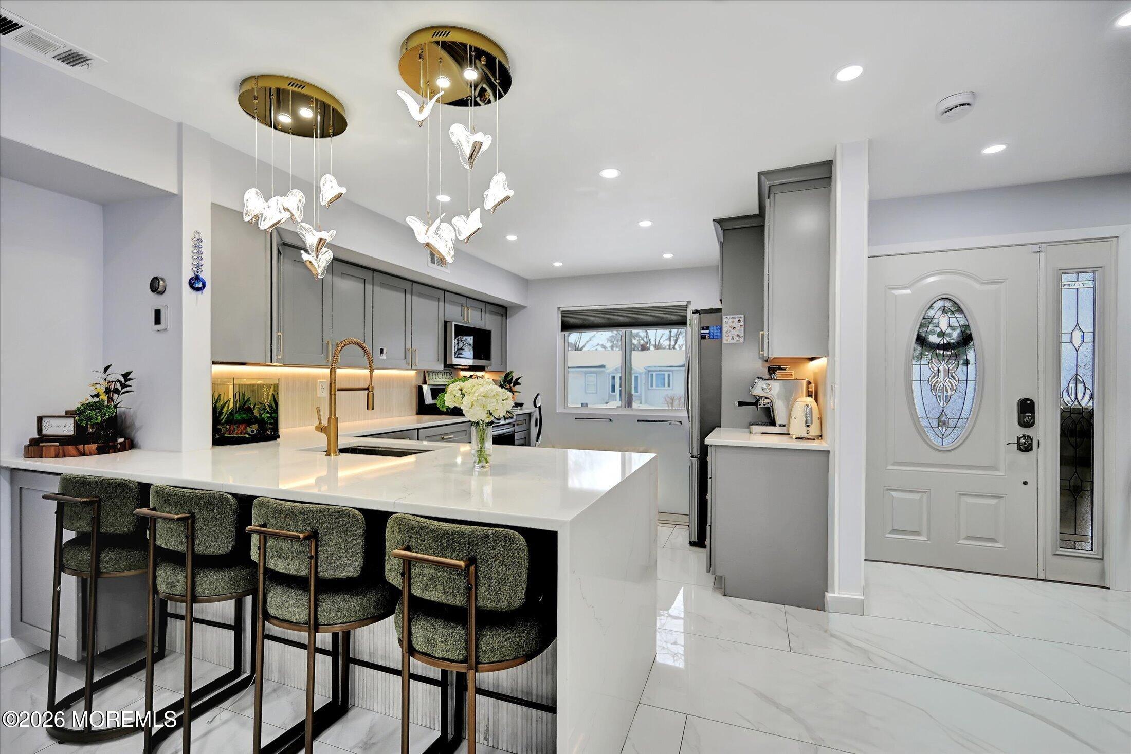 a kitchen with stainless steel appliances kitchen island granite countertop a table and chairs in it