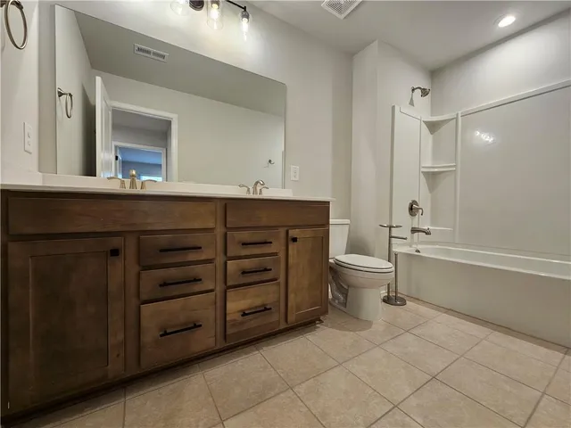 a bathroom with a double vanity sink toilet mirror and bathtub