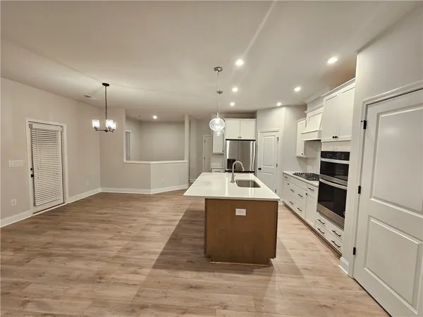 a kitchen with kitchen island a sink stainless steel appliances and cabinets