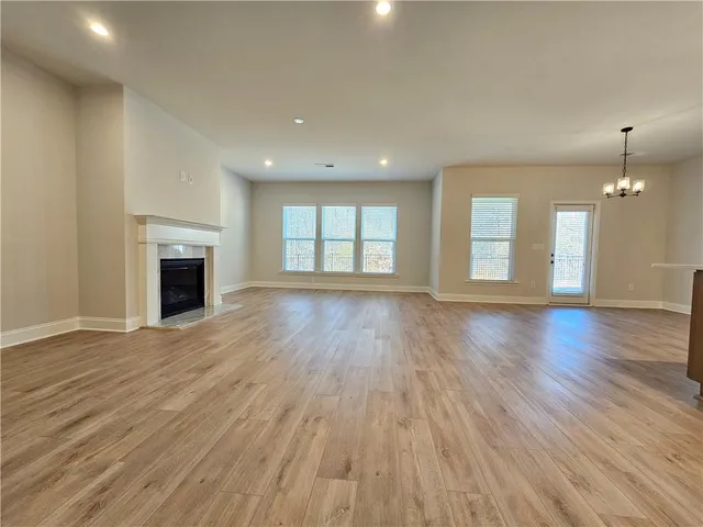 an empty room with wooden floor and fireplace