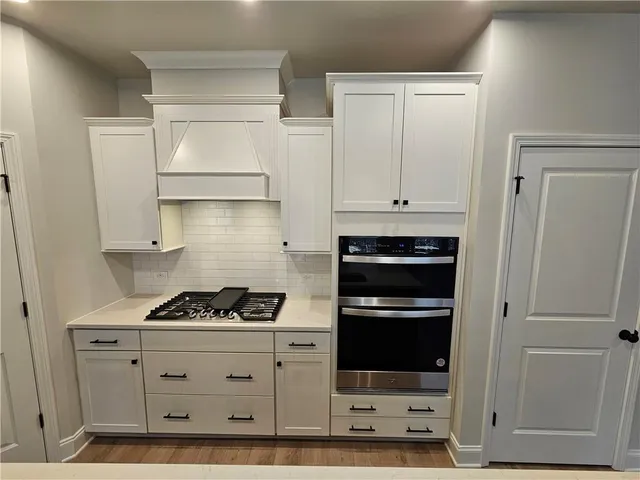 a kitchen with white cabinets and appliances